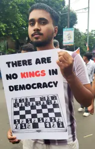 THERE ARE NO KINGS IN DEMOCRACY - Cockroach Janata Party - photograph of a young man holding a protest sign at CJP Protest Jantar Mandir